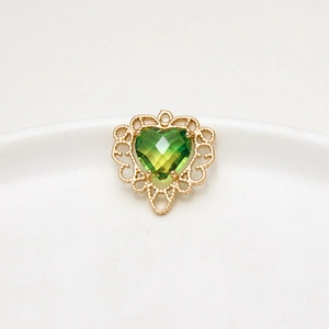 Detail van hartvormige hanger met gouden kanten rand en groene imitatie toermalijnsteen