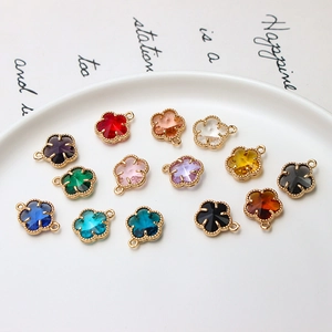 Détail de treize pendentifs floraux de 12 mm colorés sur une assiette en céramique DIY