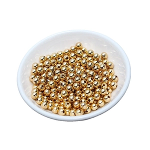 Polished 18K gold plated round copper beads for DIY jewelry making in a white bowl