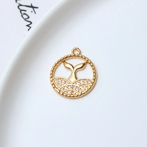 Macro detail of a gold-plated dolphin tail pendant with sparkling zircon inlays