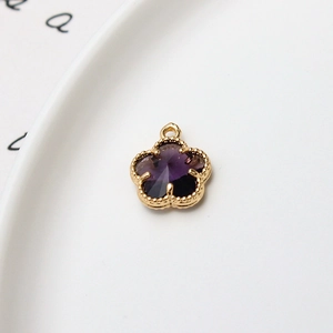 Vue macro du pendentif fleur violette 12mm avec bordure perlée dorée et anneau fermé