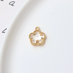 Détail d'un pendentif fleur de 12mm plaqué or avec un centre en cristal facetté