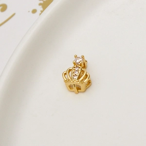 Macro detail of gold-plated crown pendant with micro-set zircons on white ceramic tray