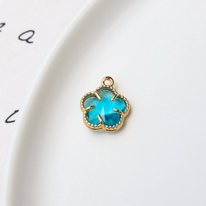 Détail d'un pendentif fleur à cinq pétales plaqué or avec pierre bleue pour bijoux