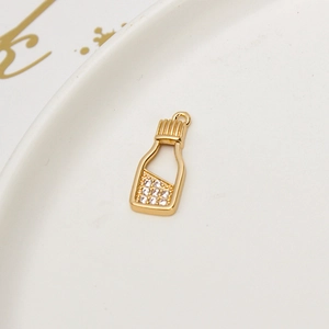 Macro detail of gold plated wishing bottle pendant with micro-paved white zircon stones