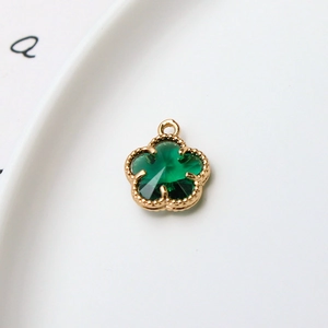 Détail d'un pendentif fleur verte 12mm à 5 pétales avec bordure dorée perlée