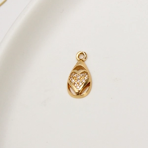 Macro shot of gold teardrop pendant featuring a micro-paved zircon heart for DIY jewelry