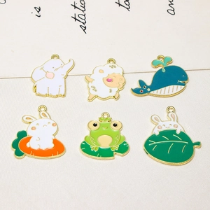 Detailed flat lay of six assorted animal enamel charms with polished gold alloy edges