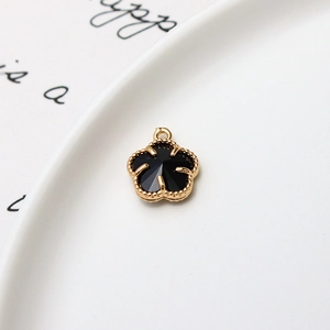Vue macro d'un pendentif fleur à cinq pétales plaqué or 12mm avec centre noir