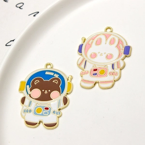 Detailed macro view of cute bear and rabbit astronaut enamel charms for DIY jewelry making