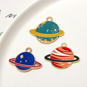 Detailed view of three colorful enamel planet charms for DIY jewelry making sets