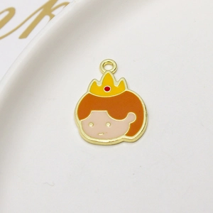 Detail of Princess Daisy enamel pendant with orange hair and golden crown in a ceramic tray