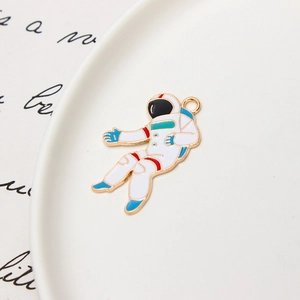 Macro view of gold astronaut enamel charm for DIY jewelry and necklace making