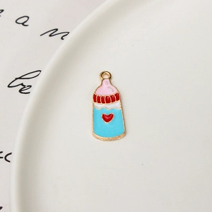 Vue détaillée d'un pendentif biberon en émail bleu avec cœur rouge et bords dorés