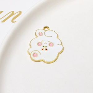 Macro shot of a cute white rabbit enamel charm with cherry pattern in a white ceramic dish