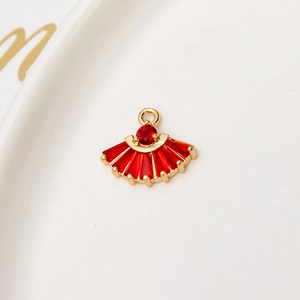 Macro-opname van een vergulde waaiervormige hanger met rode kristallen voor DIY-sieraden