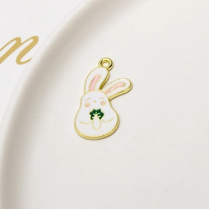 Macro shot of white rabbit enamel charm with green carrot on a ceramic plate