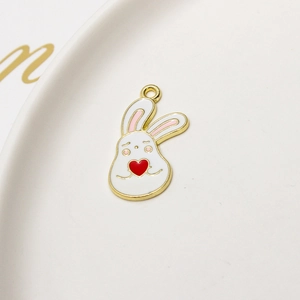 Detail showing a white enamel bunny charm with gold trim and a red heart for DIY jewelry