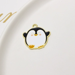 Detail showing a cute cartoon penguin alloy charm with colorful oil drip and golden plating