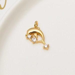Macro view of gold-plated dolphin pendant with three sparkling cubic zirconia stones
