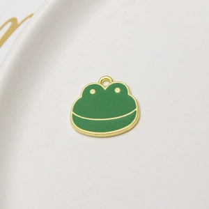 Detail view of cute green enamel frog charm on gold alloy base for DIY jewelry making