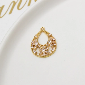 Macro shot of a hollow teardrop pendant with gold plating and white cubic zirconia crystals