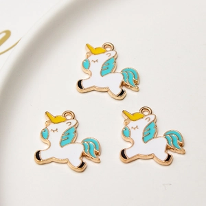 Vue détaillée de trois breloques licorne en émail blanc et métal doré pour bijoux DIY