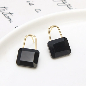 Gros plan de boucles d'oreilles cadenas en cristal noir montées sur métal doré
