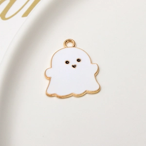 Macro shot of white enamel ghost charm with gold edges for DIY jewelry making