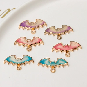 Dettaglio di ciondoli a pipistrello per Halloween con smalto sfumato glitter e bordi oro