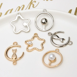 Detailed view of alloy charms including moon cat and star motifs with pearl accents