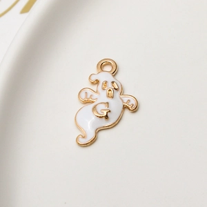 Macro view of white enamel ghost charm with golden letter G for jewelry making