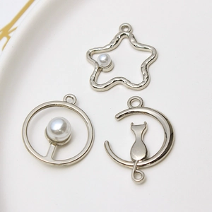 DIY jewelry charms set featuring silver star, moon cat and round pearl pendants in ceramic tray
