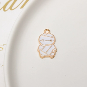 Macro detail of cartoon mummy charm in white enamel and gold finish for jewelry