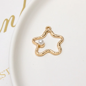 Macro shot of gold alloy star pendant with ripple texture and embedded pearl detail