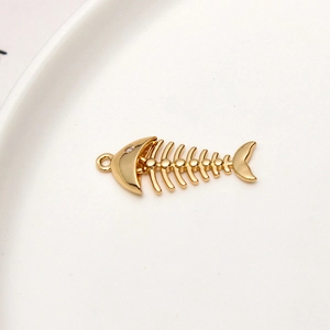 Detalle macro del colgante de espina de pescado dorado con circonita para joyería