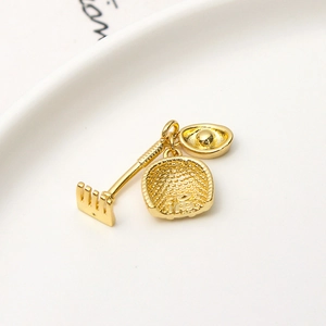 Makroaufnahme von vergoldeten Ingot- und Schaufelanhängern mit Fu-Zeichen für DIY-Schmuck