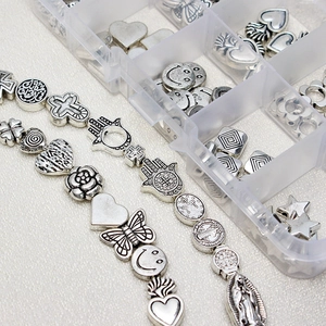 Detailed view of vintage silver alloy charms featuring heart, star, and cross motifs for DIY