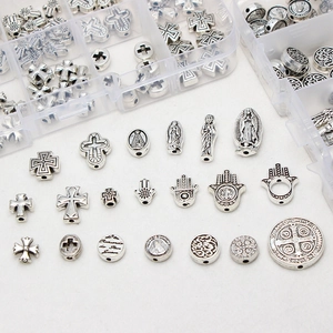 Vintage silver alloy DIY religious beads with cross and Hamsa symbols in a storage box