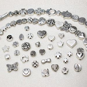 Macro view of vintage silver alloy charms featuring hearts, stars, and butterflies