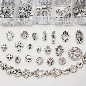 Macro view of vintage silver alloy religious charms, crosses and beads for DIY jewelry