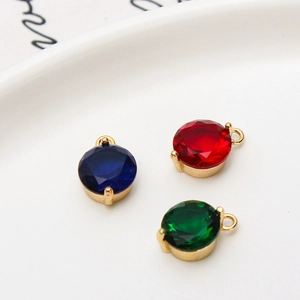 Macro view of 8mm round zircon charms in blue, red and green with gold plating