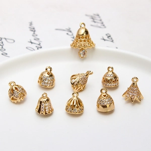 Macro view of gold-plated bell pendants with micro-pave cubic zirconia for jewelry making