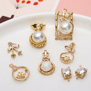 Golden lucky bag and cherry hollow pearl pendants arranged on a white ceramic plate