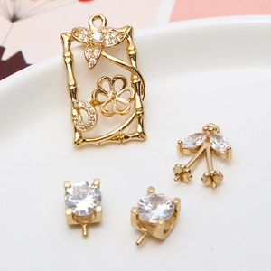 Macro detail of gold DIY jewelry pendants with cherry and bamboo floral hollow designs