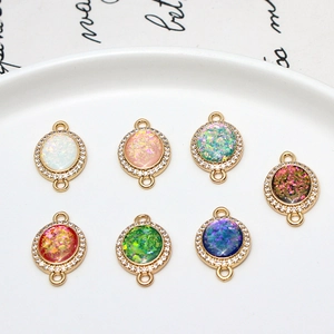 Lot de 7 pendentifs ovales dorés avec pierres effet opale et bordure en zircons brillants