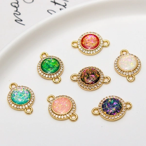 Macro view of gold-plated round pendants with faux opal and sparkling zircon inlay