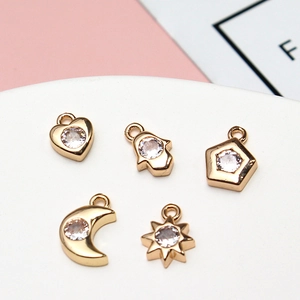 Macro shot of gold-plated geometric heart and moon charms with sparkling zircon stone