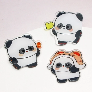 Three cute cartoon panda acrylic badges with various accessories on white display