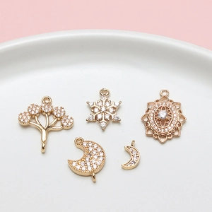 Detalle de colgantes de cobre dorado con circonitas para la creación de joyas DIY